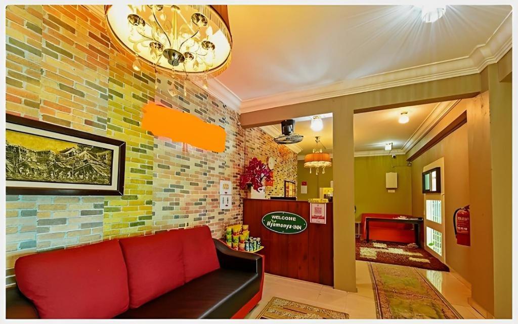 a living room with a couch and a brick wall at Nyamanya Inn Kuantan in Kampong Alor Akar