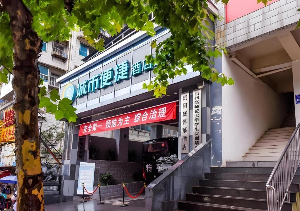 a building with a red and white sign on it at City Comfort Inn Hotel Guiyang Normal University Yangmingci Metro Station in Guiyang