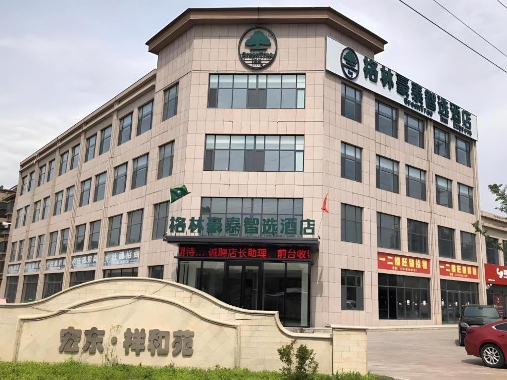 a building with a sign on the front of it at GreenTree Inn Express Qingdao Laixi High-Speed Railway Station Shenzhen Road in Laixi