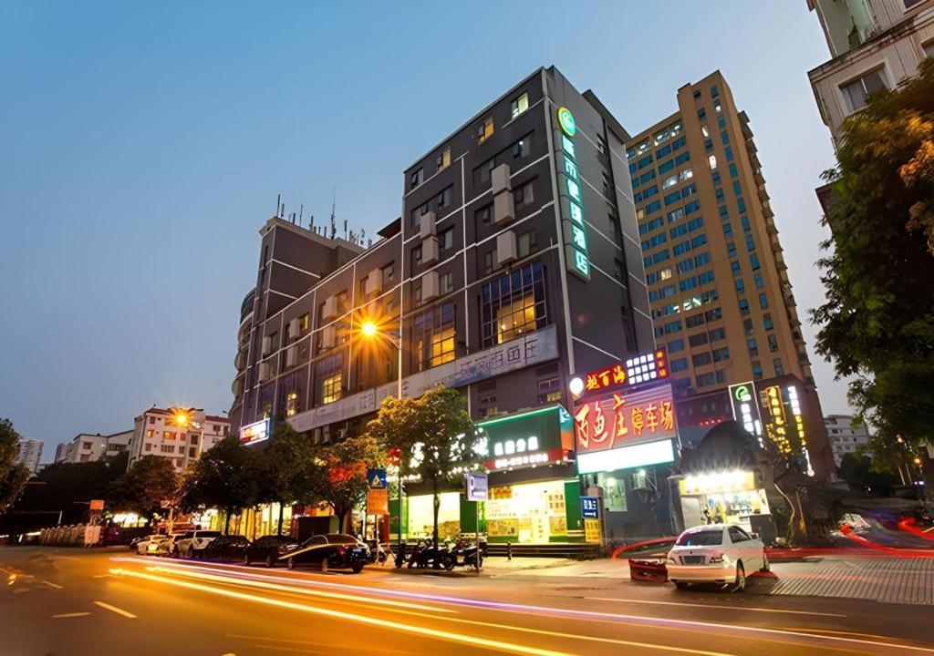 a city street at night with cars and buildings at City Comfort Inn Nanning Jinhu Plaza Langxi Metro Station Exhibition in Nanning