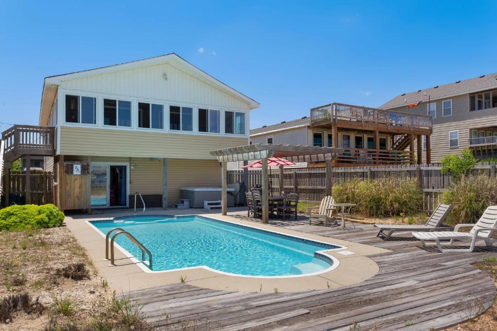 a backyard with a swimming pool and a house at 4122 - Blue White Haven in Kitty Hawk