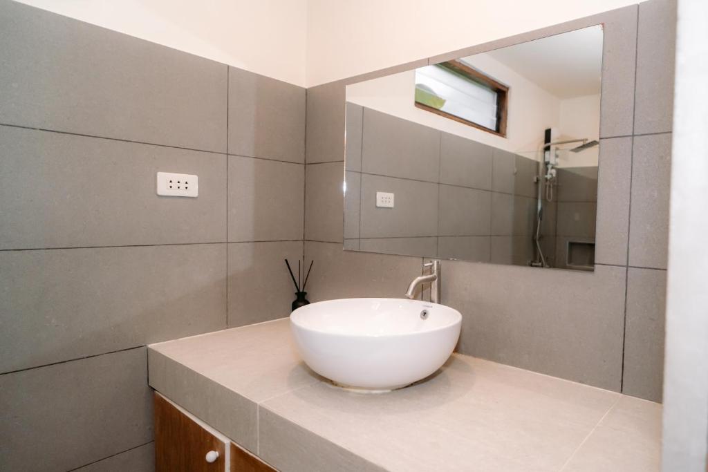 a bathroom with a white sink and a mirror at Surfer's Hideout in General Luna
