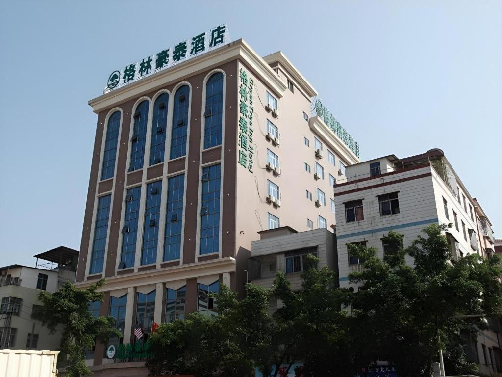 wysoki biały budynek z chińskim napisem w obiekcie GreenTree Inn Guangdong Huizhou Chenjiang Intercity Rail Station Business Hotel w mieście Huizhou