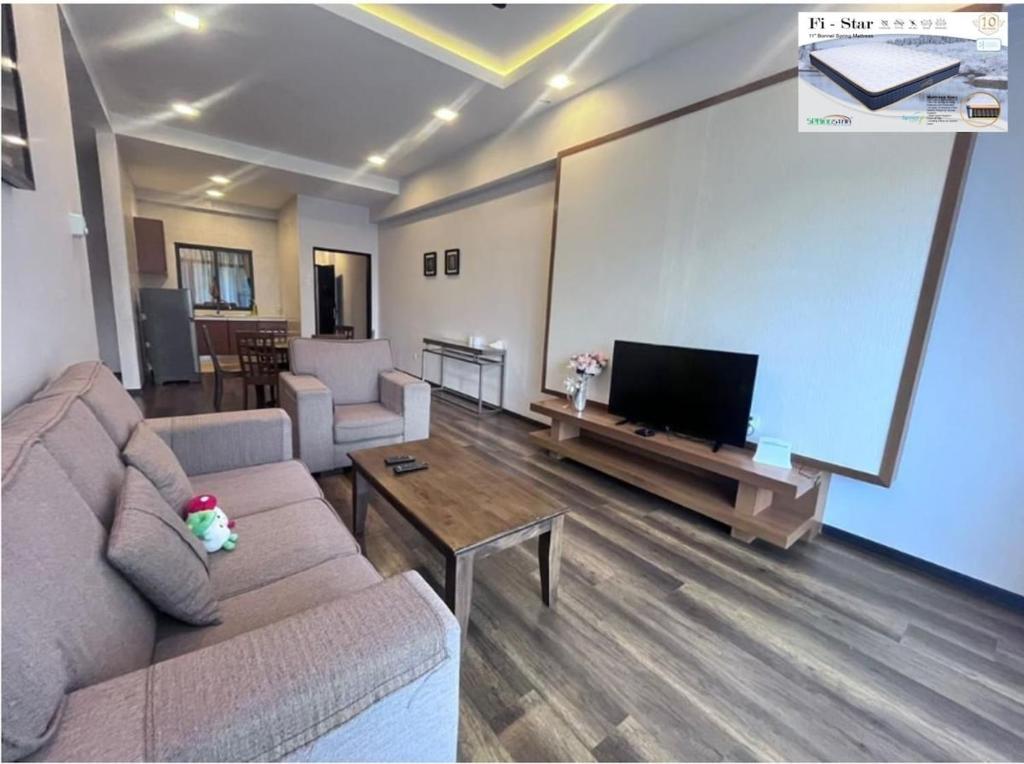 a living room with a couch and a large projection screen at Nova Mountain n Sunrise view Hilltop Hotel Apartment in Cameron Highlands in Cameron Highlands