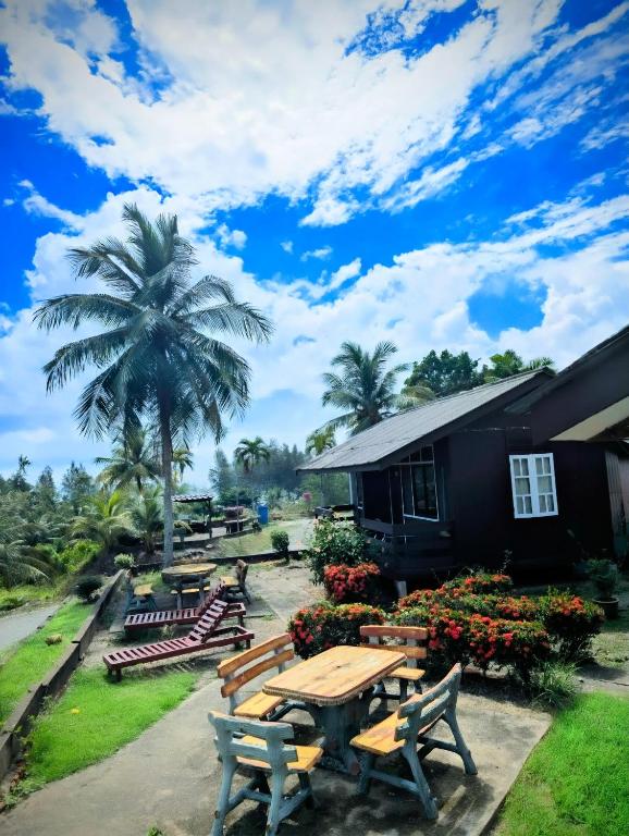 马兰Marang Guesthouse Resort的大楼前的野餐桌和长凳