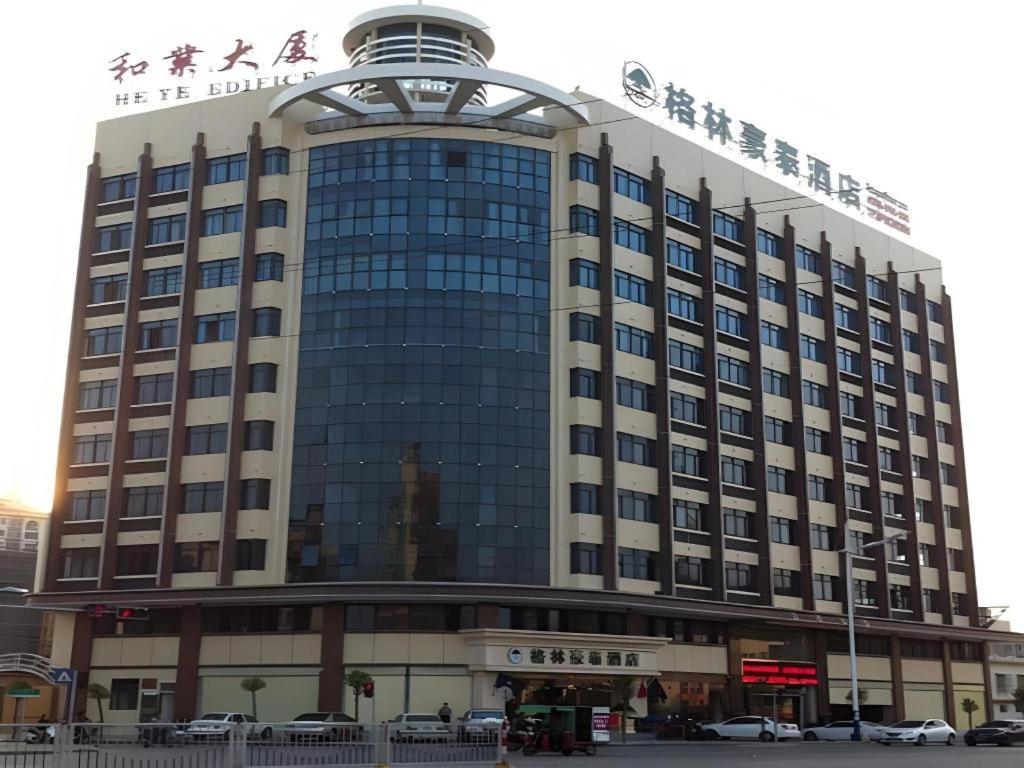 un grand bâtiment avec une enseigne au sommet dans l'établissement GreenTree Inn Shantou Chengjiang Road Business Hotel, à Xialian