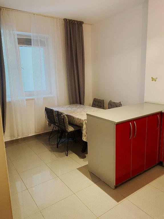a room with a table and a table and chairs at Red apartament in Bucharest