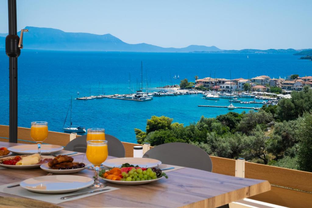 a table with food and drinks and a view of a harbor at Diamanti Villas in Nikiana