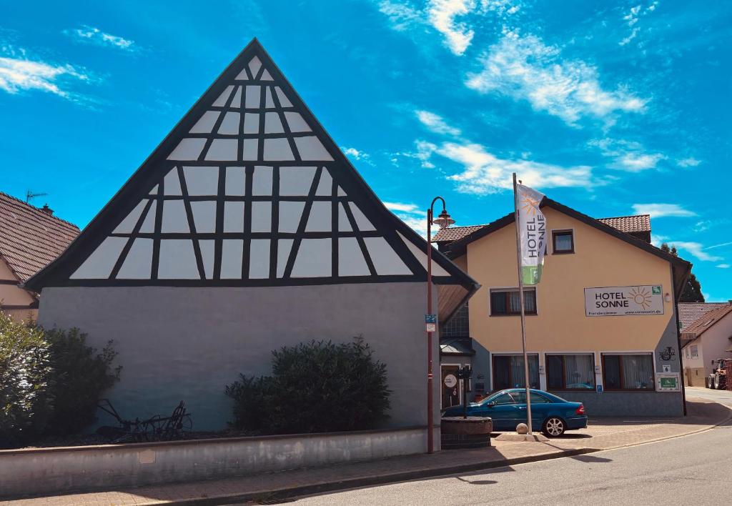Un edificio con un techo triangular en el costado. en Hotel Sonne, en Sinsheim