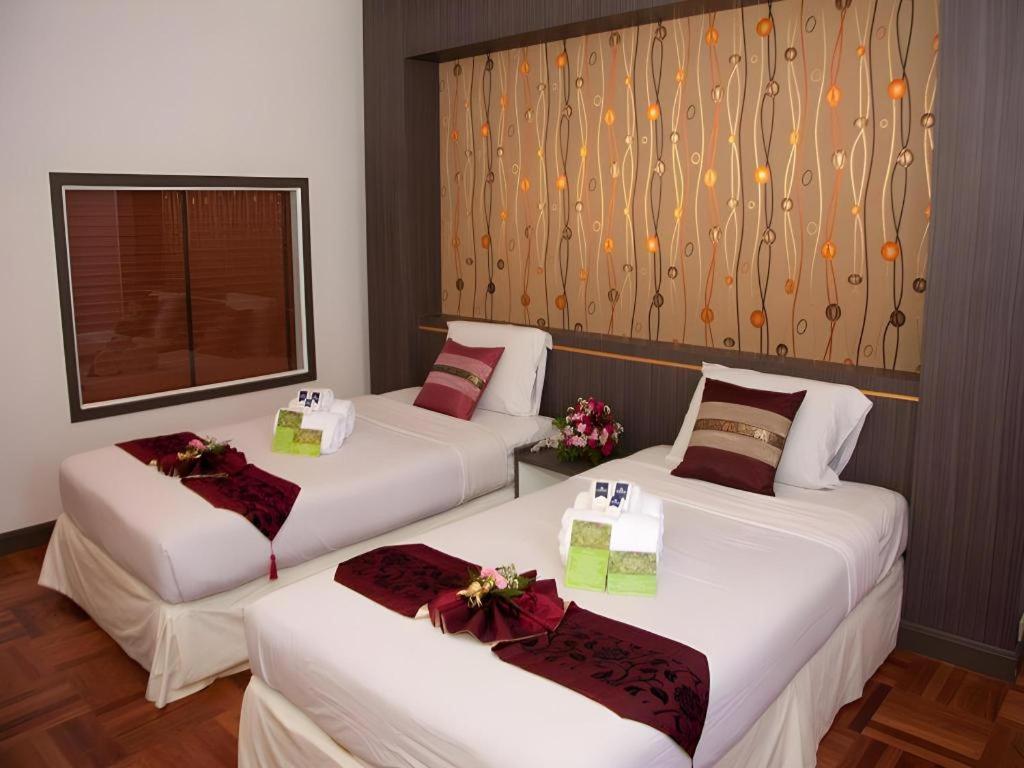 two beds in a hotel room with presents on them at Ayutthaya Grand Hotel in Ban Han Tra Fang Nua