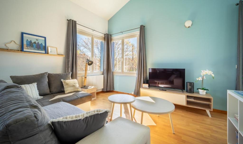 un salon avec un canapé et une télévision dans l'établissement SAURET : Havre de paix en ville : spacieux et confortable, à Montpellier