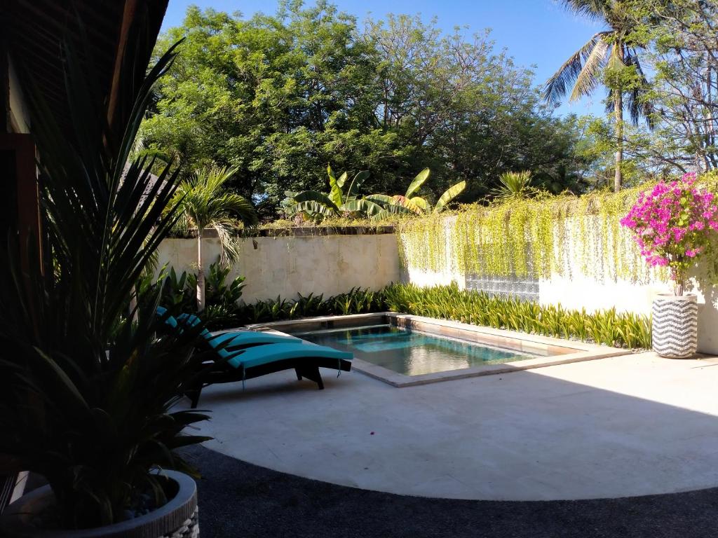 una piscina en un jardín con una fuente en Gili Palms Villas, en Gili Trawangan