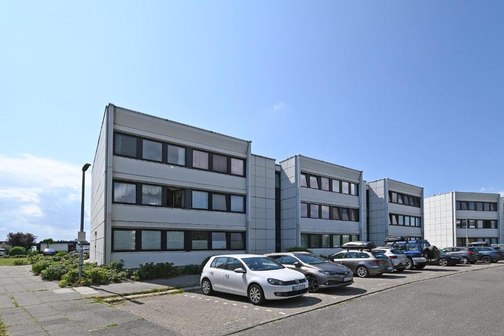 a parking lot with cars parked in front of a building at Ferienwohnung Thordsen 2 in Burgtiefe auf Fehmarn 