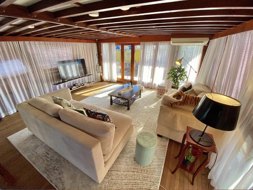 a living room with two couches and a television at The Oak & Anchor - Hong Kong Houseboat in Hong Kong