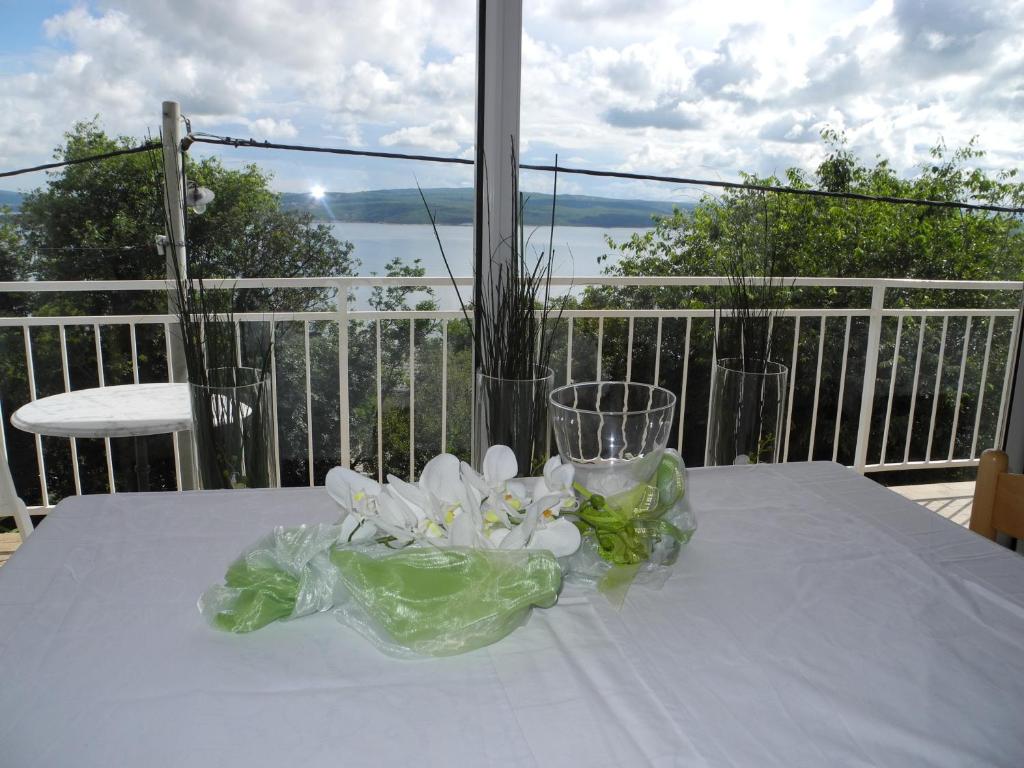 a white table with a vase of flowers on it at Privathaus Marija in Dramalj