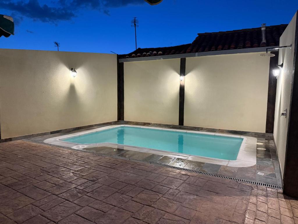 una piscina en el lateral de una casa por la noche en Hotel Rural Alecook, en Valcabado
