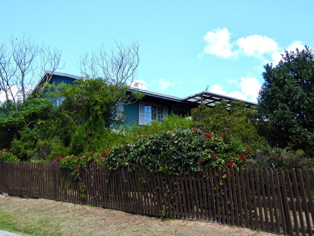 a fence in front of a house with red roses at Sedgefield Vacation Home in Sedgefield