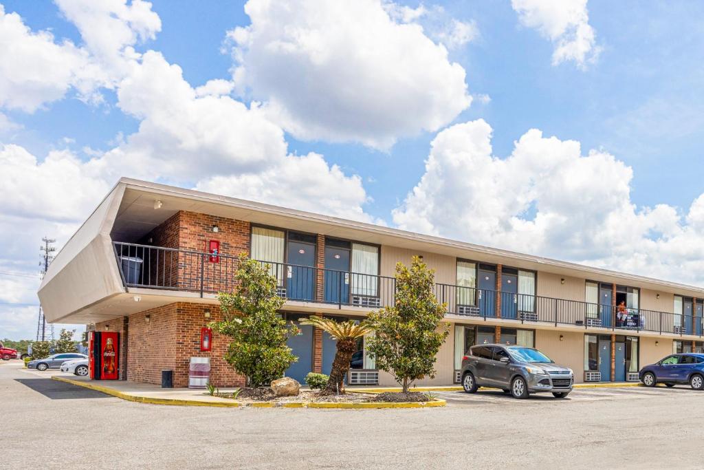 a building with cars parked in a parking lot at Oyo Hotel Bartow in Bartow