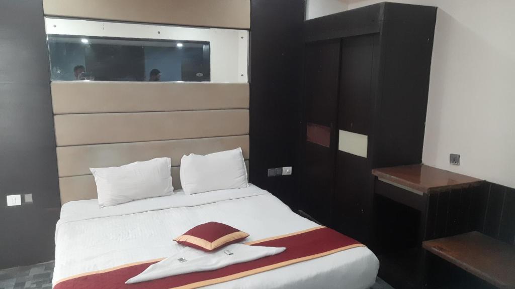 a bed with a hat and a towel on it at Hotel Namaste Inn in Hyderabad