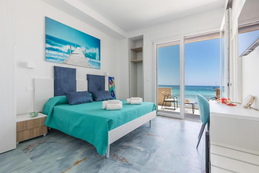 a bedroom with a bed with a view of the ocean at Nella Suites Rooms in Torre Lapillo