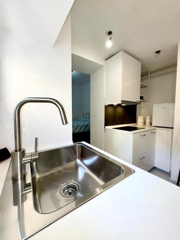 a kitchen with a stainless steel sink and white cabinets at Residence Zar 9 in Trieste