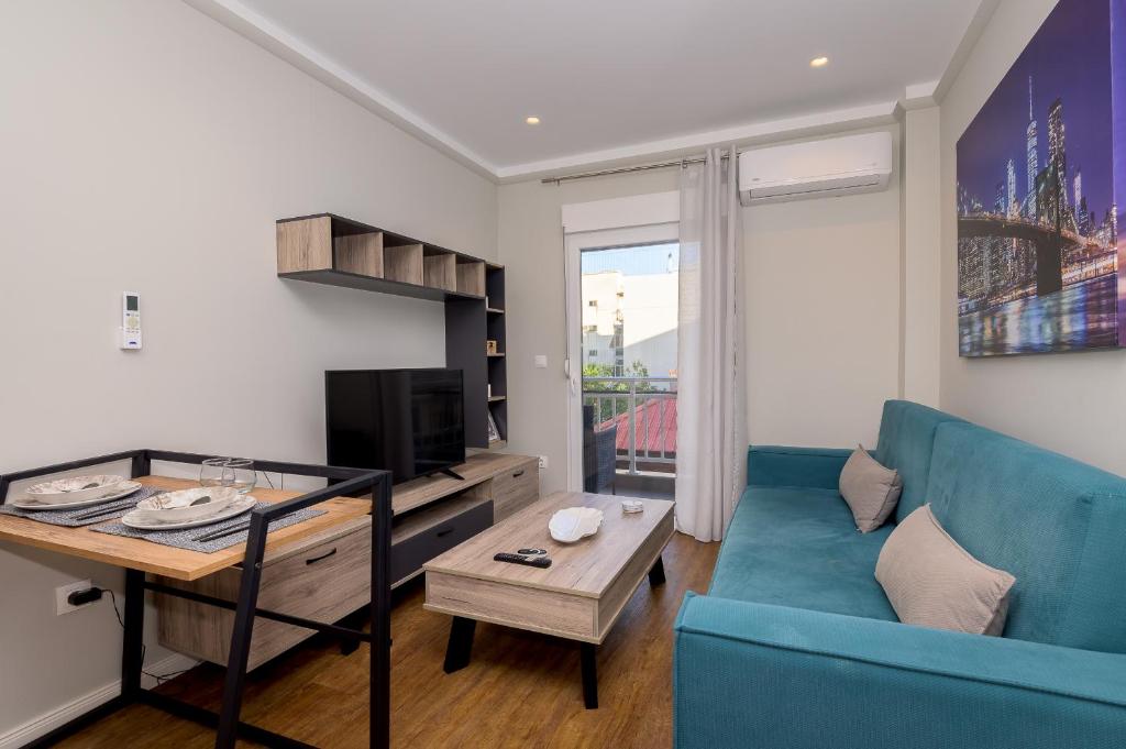 a living room with a blue couch and a table at Mint - Lux Apt 1 in Alexandroupoli