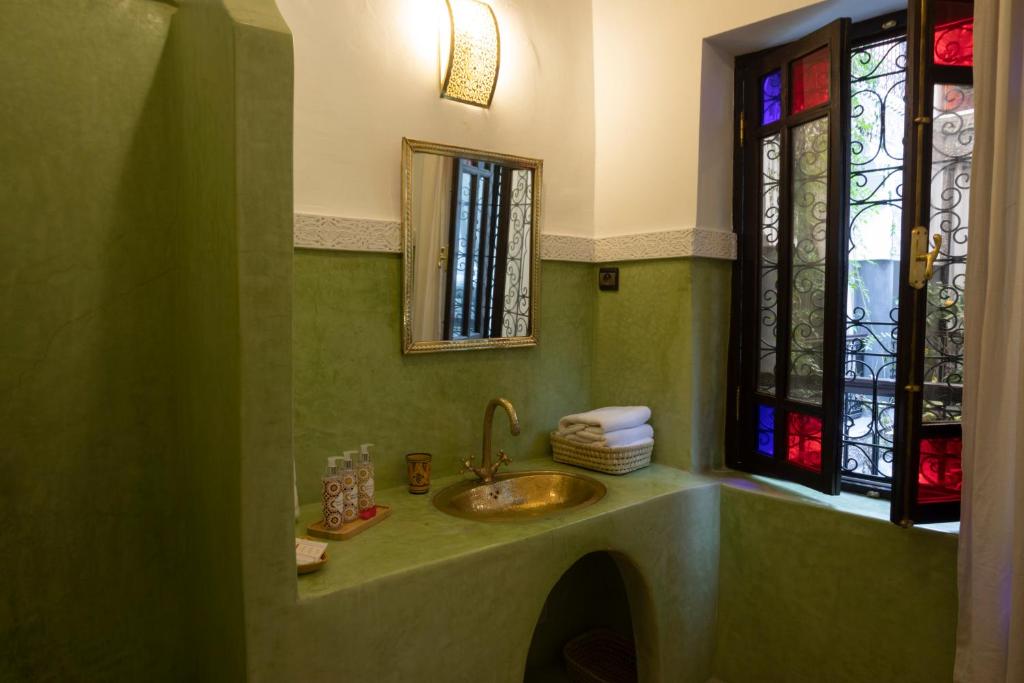 une salle de bain avec un lavabo et un vitrail dans l'établissement Riad O'Zeen, à Marrakech