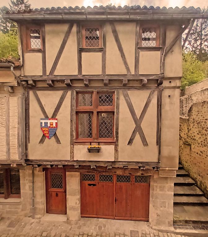 an old building with a shield on the side of it at Gite medieval St Jacques in Parthenay