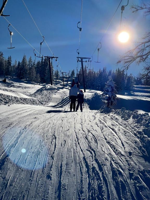 a couple of people on a ski lift in the snow at Appartement Silbermond in Schladming
