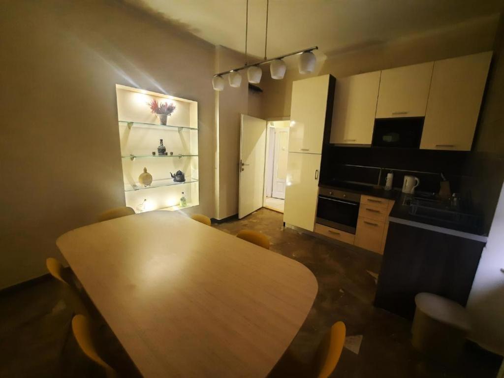 een keuken met een houten tafel en stoelen in een kamer bij Authentic Belgrade Centre - New Year 2026 - 2 Apartments for large Groups in one building in Belgrado