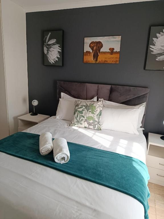 a bedroom with a bed with two towels on it at Cleo's Corner in East London