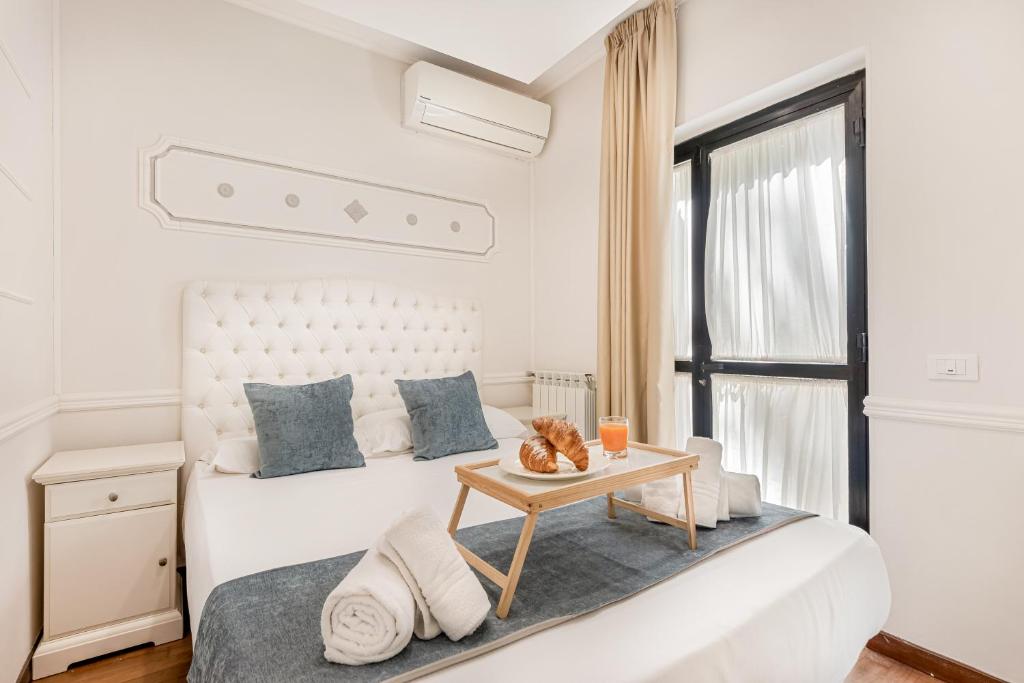 une chambre blanche avec un lit et une table dans l'établissement GOLDEN LUXE - Seafront Terrace next to the Beach, à Marina di Pietrasanta