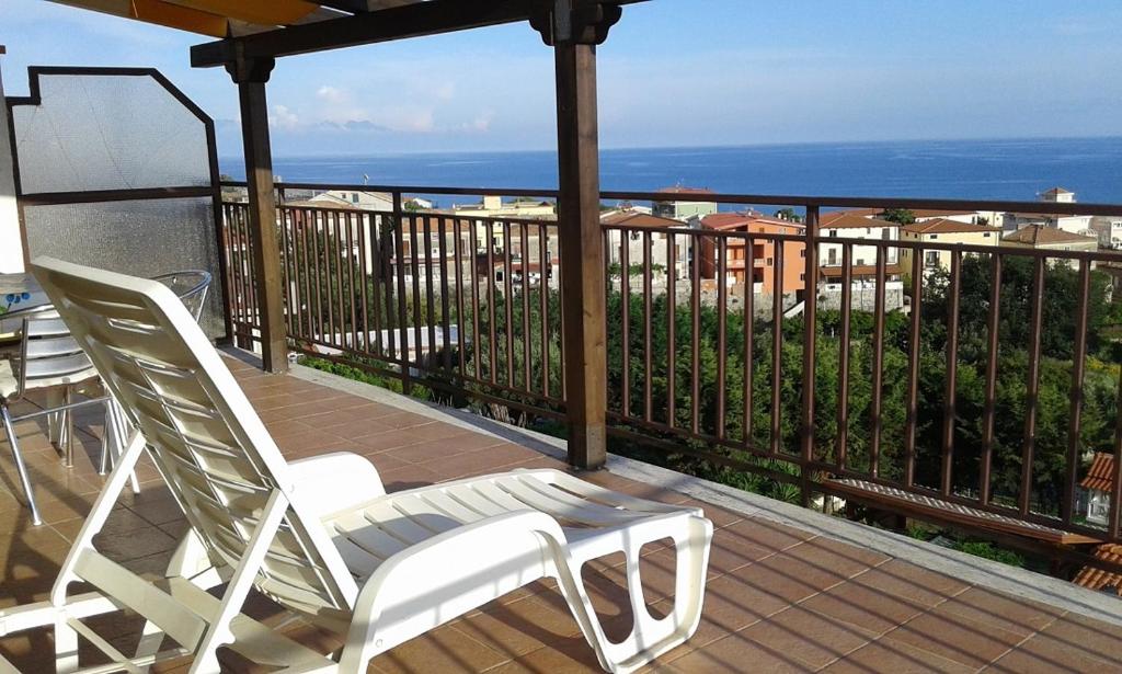 un paio di sedie bianche sedute su un balcone di Casa Vacanza Orizzonte a Marina di Camerota