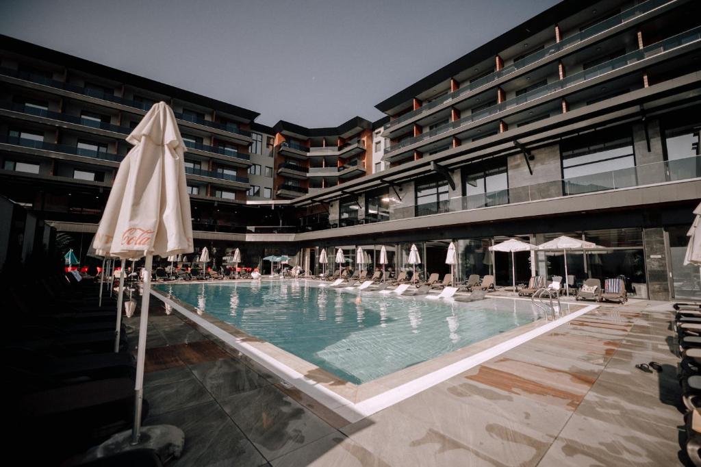 a large pool with chairs and umbrellas in a building at Santé SPA Hotel in Velingrad