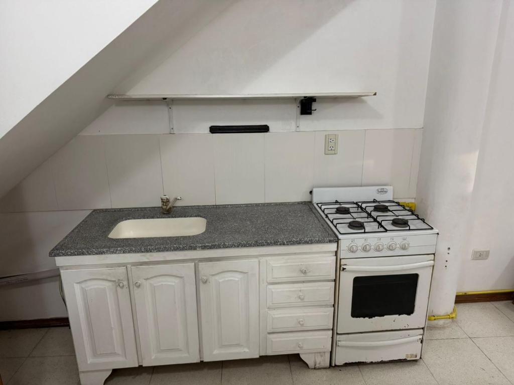eine Küche mit Herd und Spüle in der Unterkunft Departamento en pleno centro in San Miguel del Monte