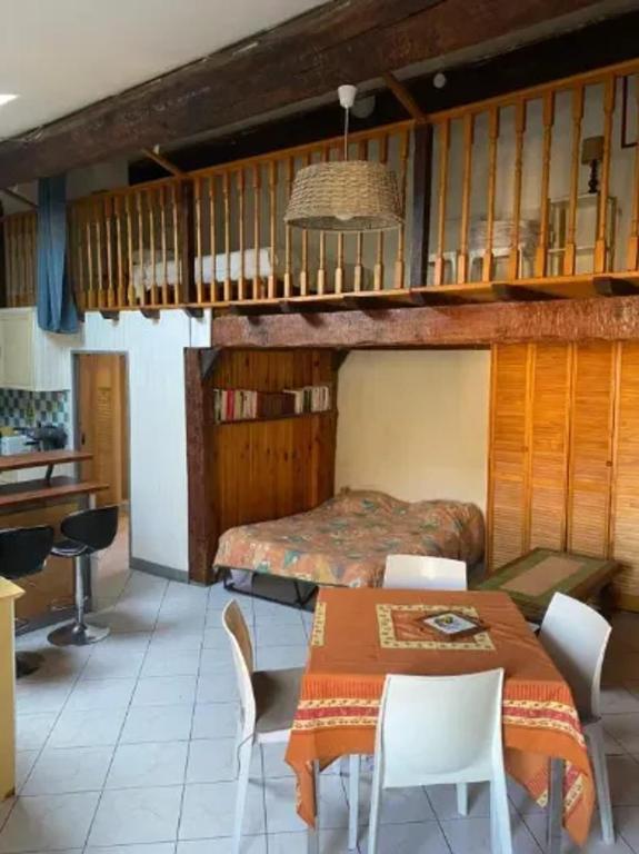 une chambre avec un lit, une table et des chaises dans l'établissement Maison chaleureuse à Ille-sur-Têt, jardin paisible, clim & cheminée, à Ille-sur-Têt