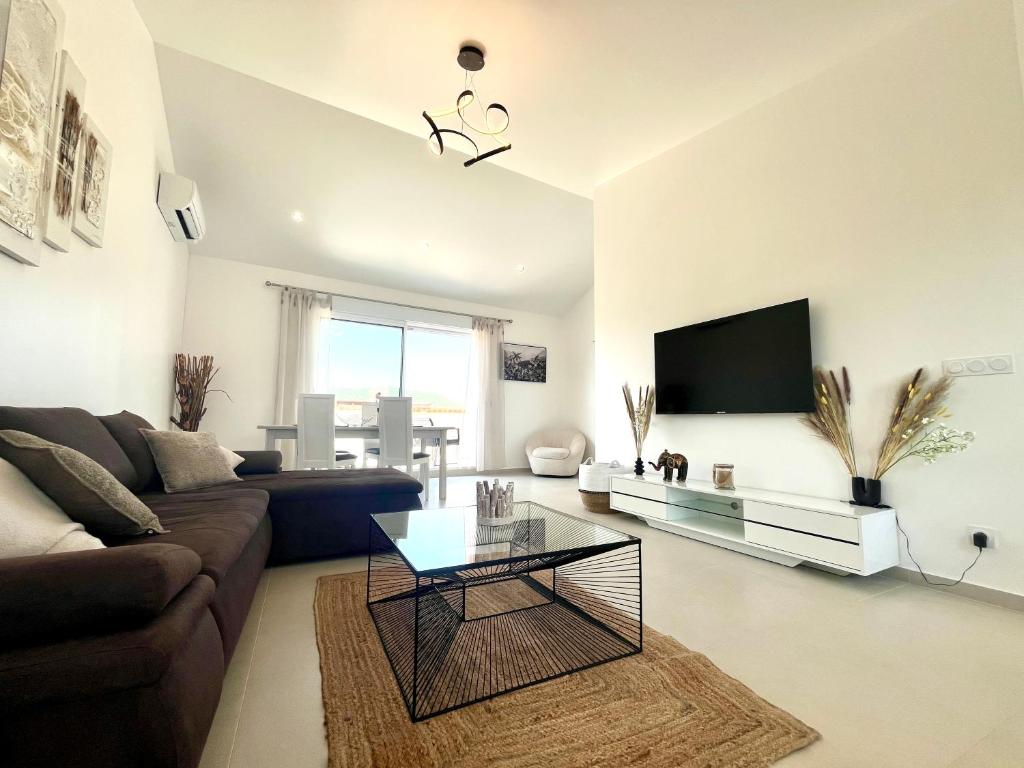 a living room with a couch and a tv at Cosy village Home with Horizon in Bagnols-en-Forêt