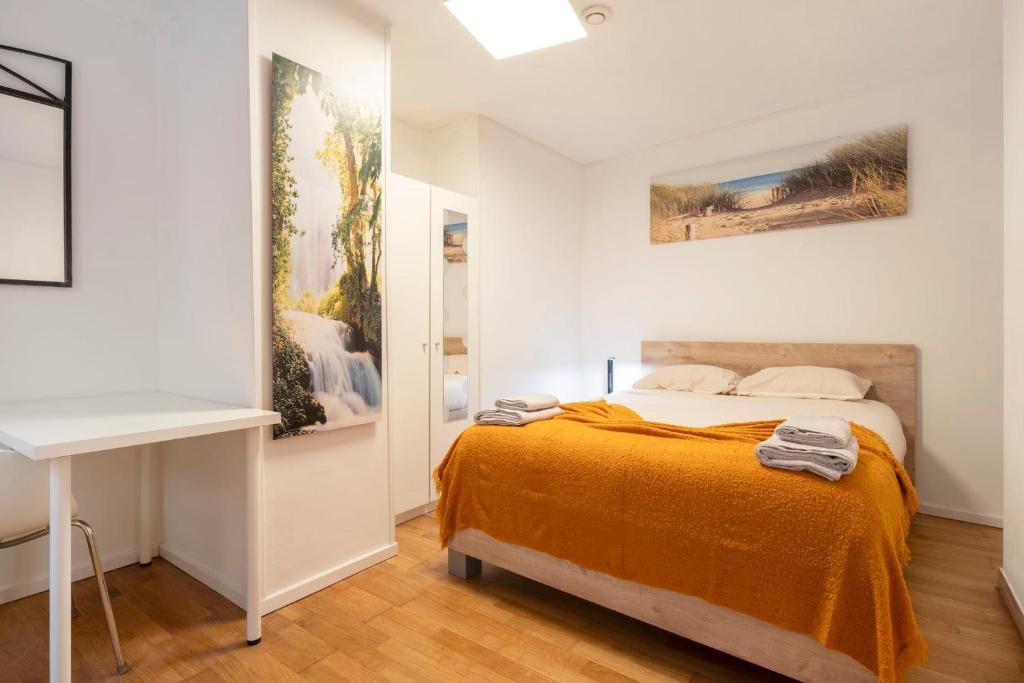 a bedroom with a bed and a painting on the wall at L'écrin du fort - deux chambres parking gratuit in Luxembourg