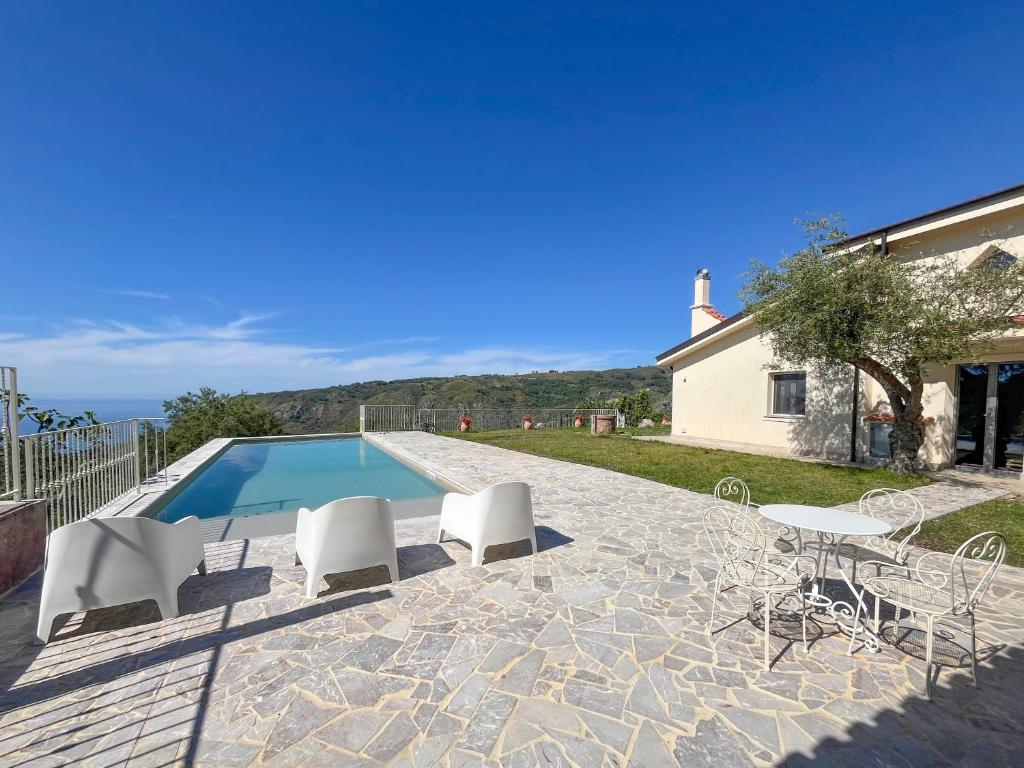 a villa with a swimming pool and white chairs at Villa Gisella in San Marco dʼAlunzio