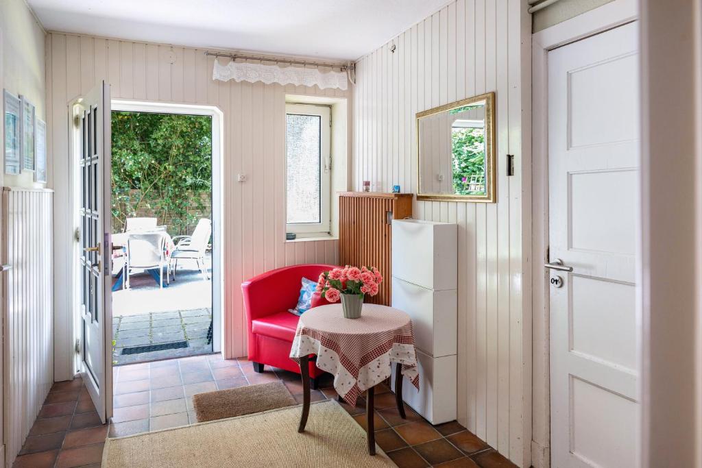 a living room with a red chair and a table at Haus Helene Clausen in Waldhusen