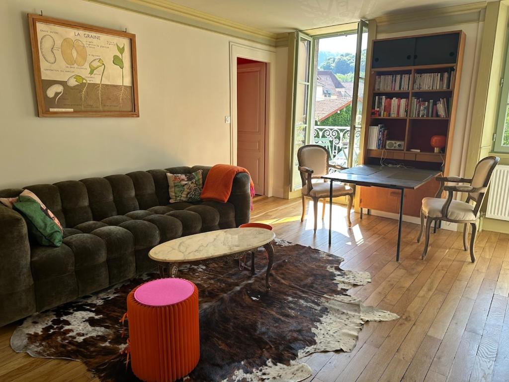 ein Wohnzimmer mit Sofa und Tisch in der Unterkunft Le Relais de Paulette et Gaston in Poligny