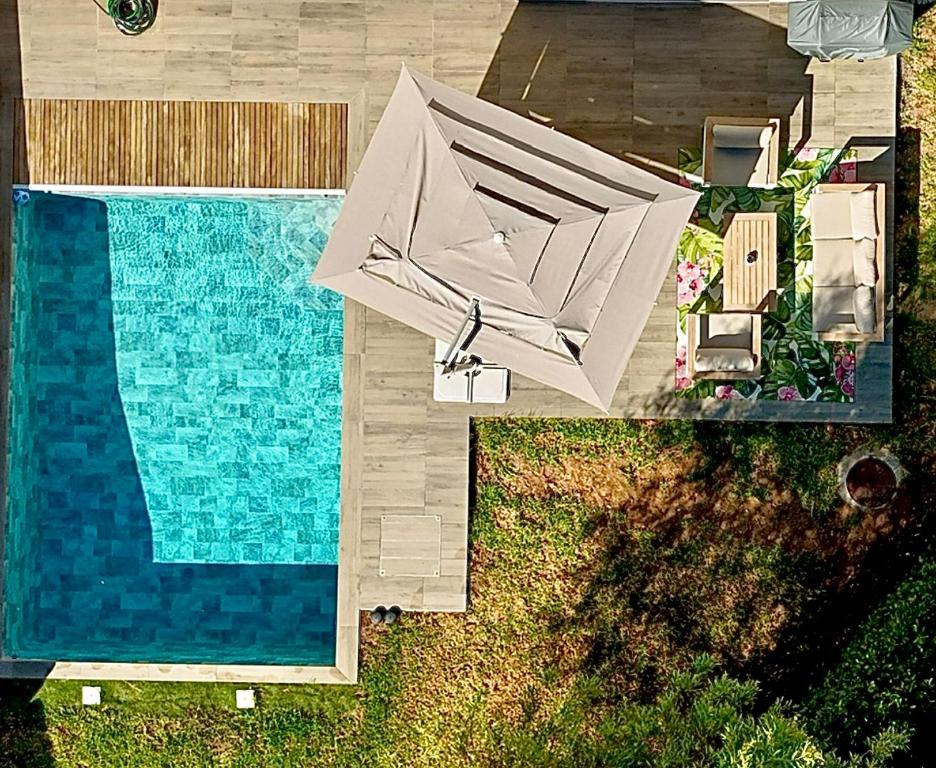 une vue aérienne d'une piscine avec un parasol à côté d'une piscine dans l'établissement La Villa Blanche, à Cavalaire-sur-Mer