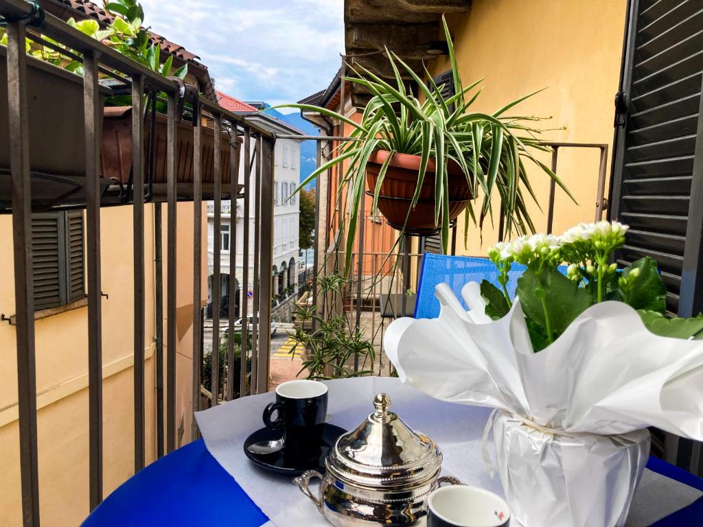 a table with a vase of flowers on a balcony at Porta 1 in Luino