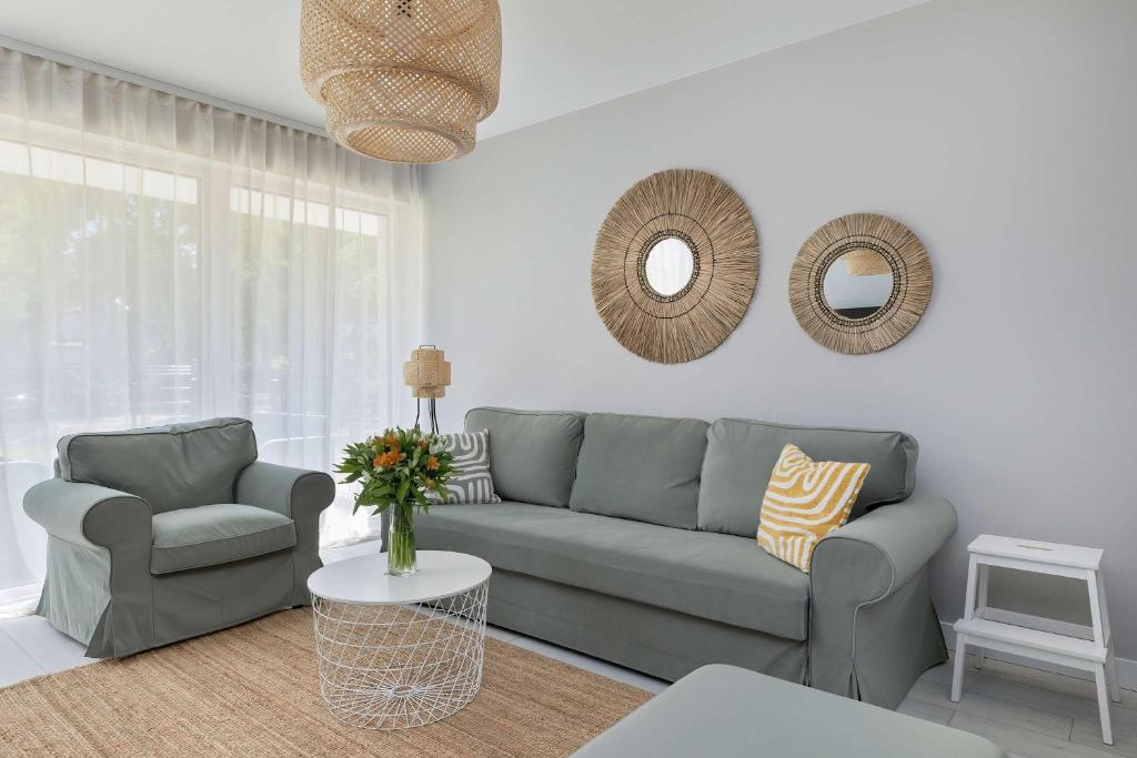 a living room with a couch and a chair at Urokliwy Apartament z Ogródkiem 150 m od Plaży Parking Międzywodzie by Noclegi Renters in Międzywodzie