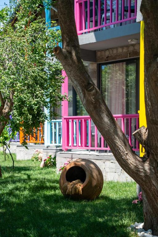 a colorful house with a large tree at Sokakağzı Otel & Beach in Ayvacık