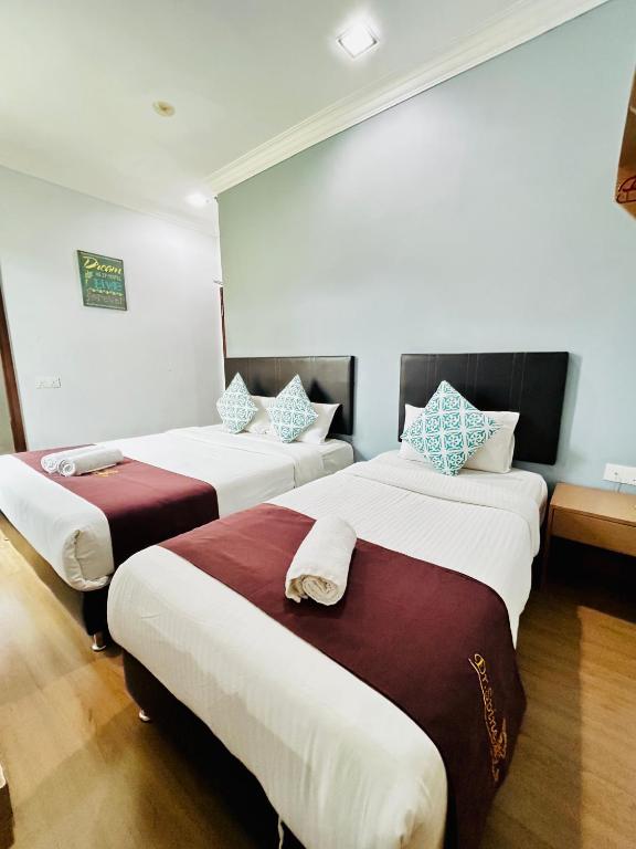 a room with two beds in a room at Charisma Hotel Self Check-In in Kuantan