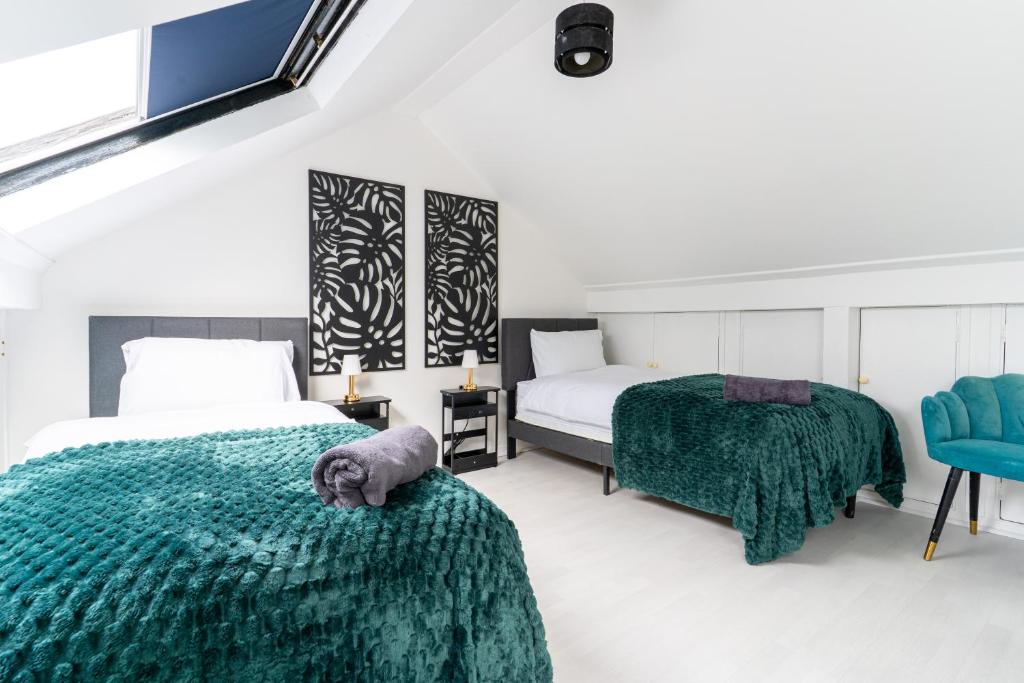 1 Schlafzimmer mit 2 Betten und einer grünen Tagesdecke in der Unterkunft NEW Spacious House 6 Bedrooms 4Bathrooms 10 Guests in Romford