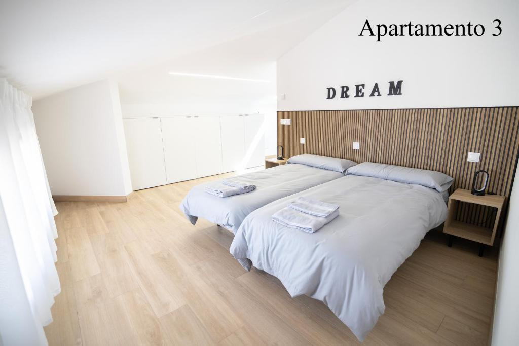 una camera da letto con un letto con due asciugamani sopra di Apartamentos LA PARRILLA a La Parrilla