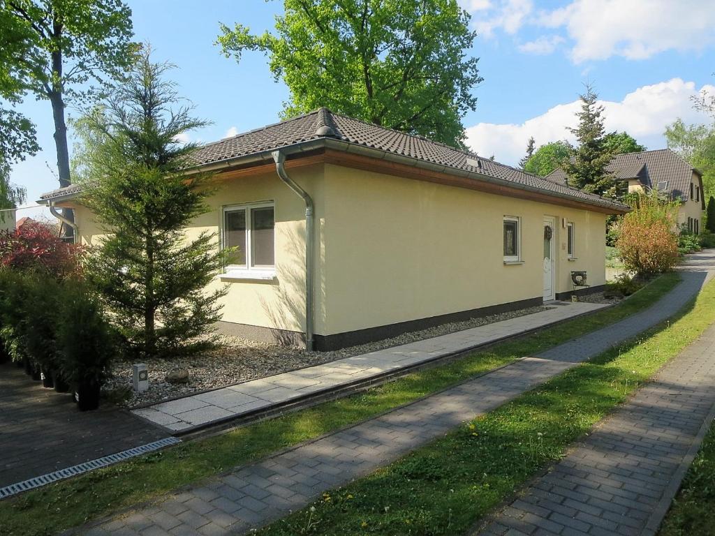 una pequeña casa amarilla con entrada en Ferienhaus Schillo en Rangsdorf