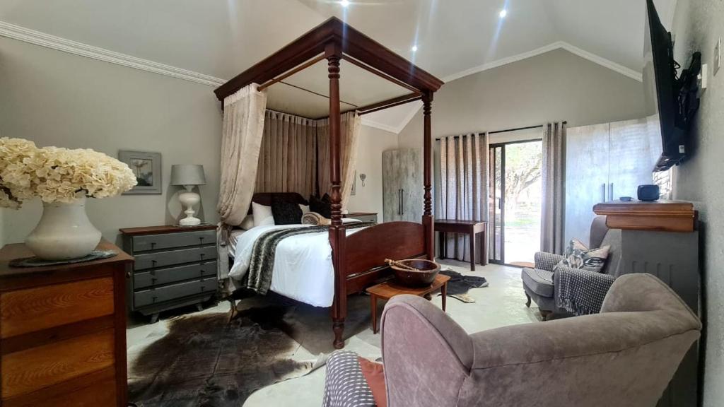 a bedroom with a large canopy bed and a chair at Lala Panzi in Ghanzi